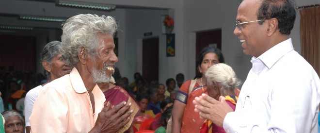 An elderly man thanking Cletus Babu for his support
